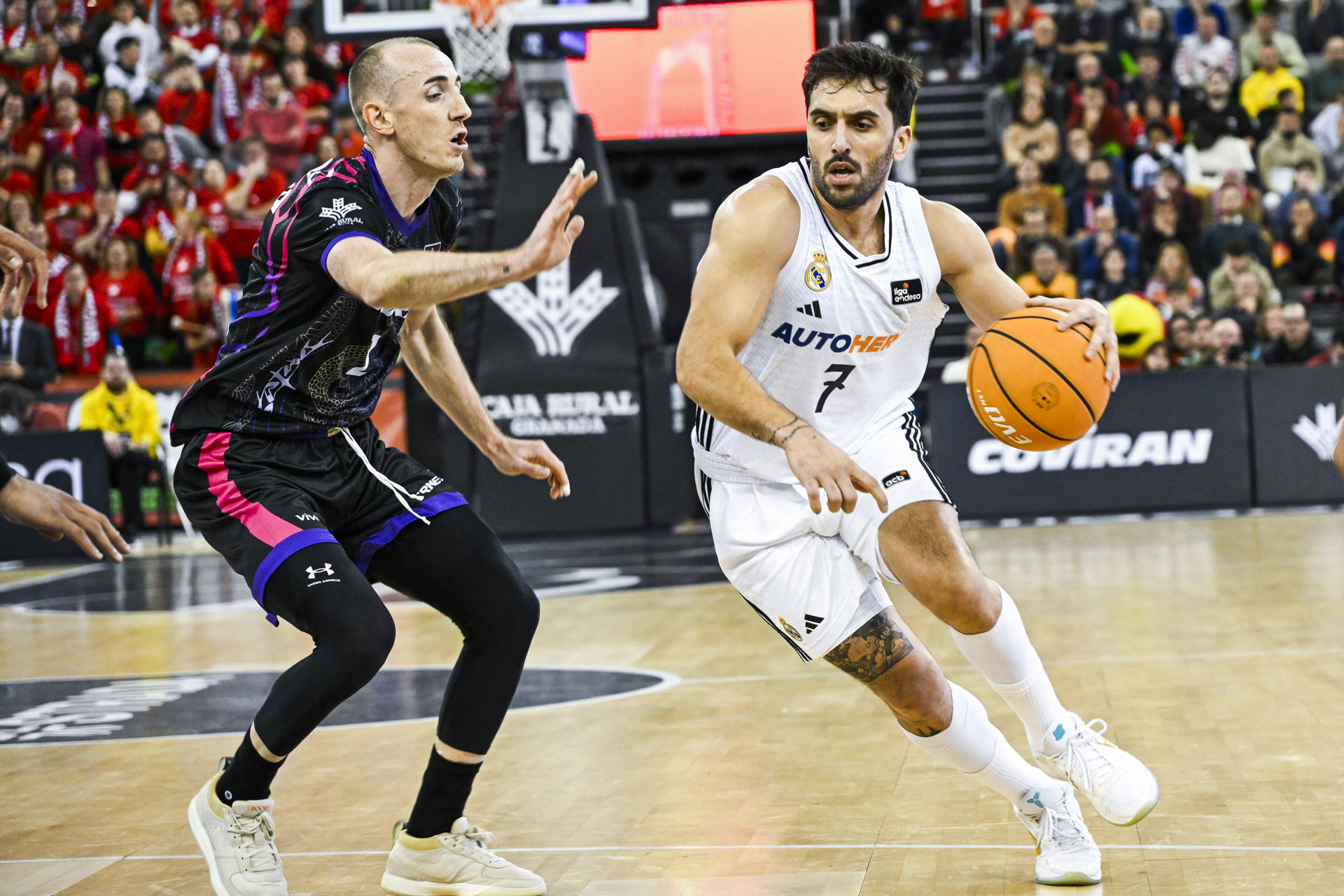 El base argentino del Real Madrid Facundo Campazzo (d) intenta superar a Jonathan Rousselle, del Covirán Granada, durante el partido de la jornada 14 de la Liga Endesa que Covirán Granada y Real Madrid disputaron en el Palacio de Deportes de Granada. EFE/miguel ángel molina
