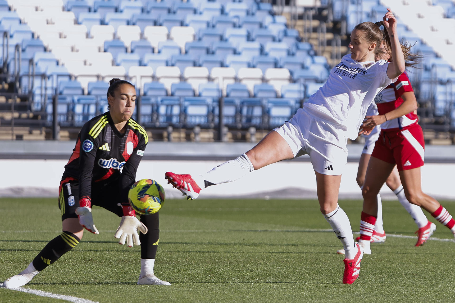 La centrocampista francesa del Real Madrid Sandie Toletti (c) intenta un remate ante la portera del Granada Sandra (i) durante el partido de Liga F entre el Real Madrid y el Granada, este domingo en el estadio Alfredo di Stéfano de Madrid. EFE/ Sergio Pérez
