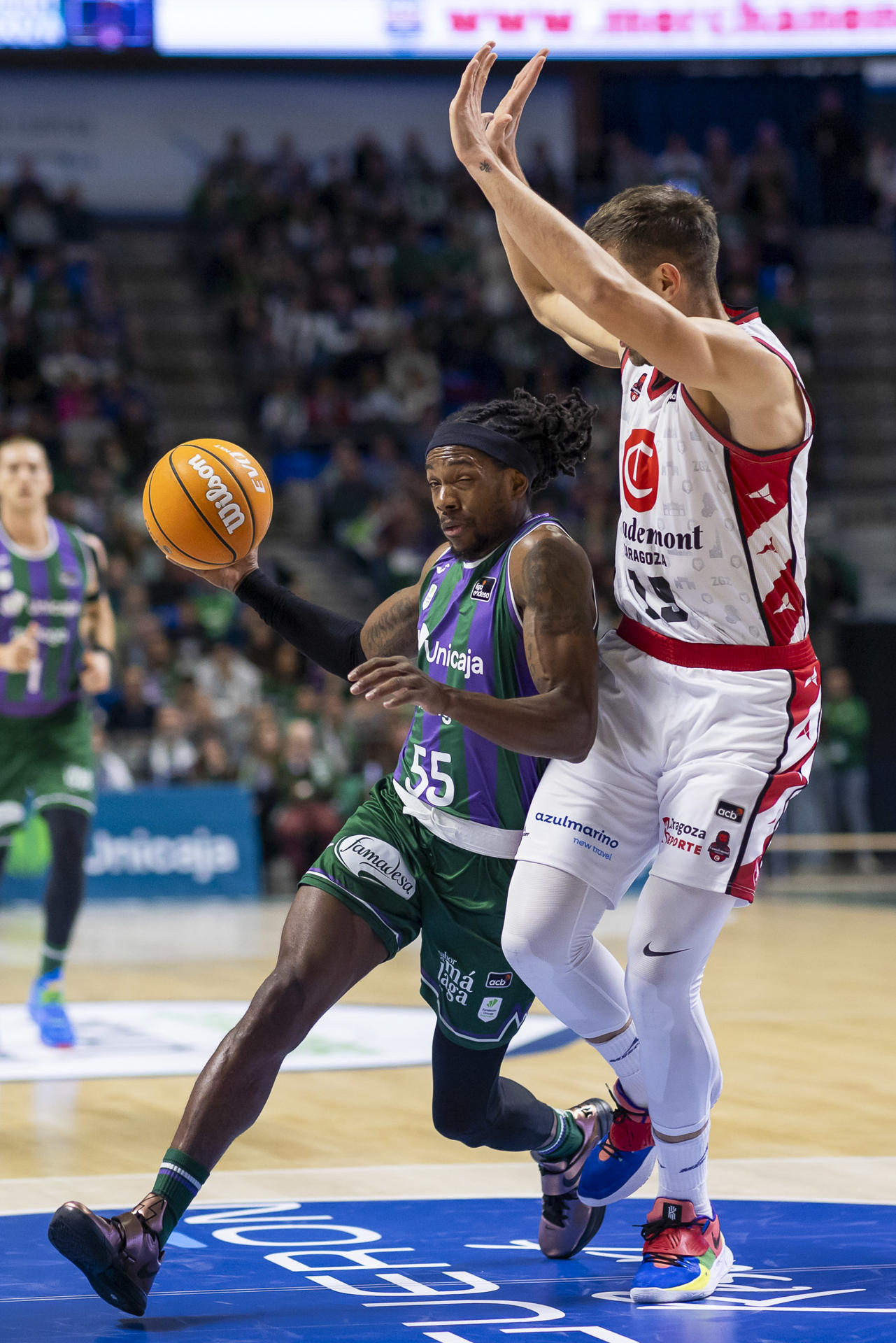 El base estadounidense del Unicaja, Kendrick Perry (i) entra a canasta ante el ala-pívot bosnio del Casademont Zaragoza, Emir Sulejmanovic (d) durante el partido de la decimoquinta jornada de la liga Endesa disputado este sábado en el Palacio de Deportes José María Martín Carpena.- EFE/ Carlos Díaz
