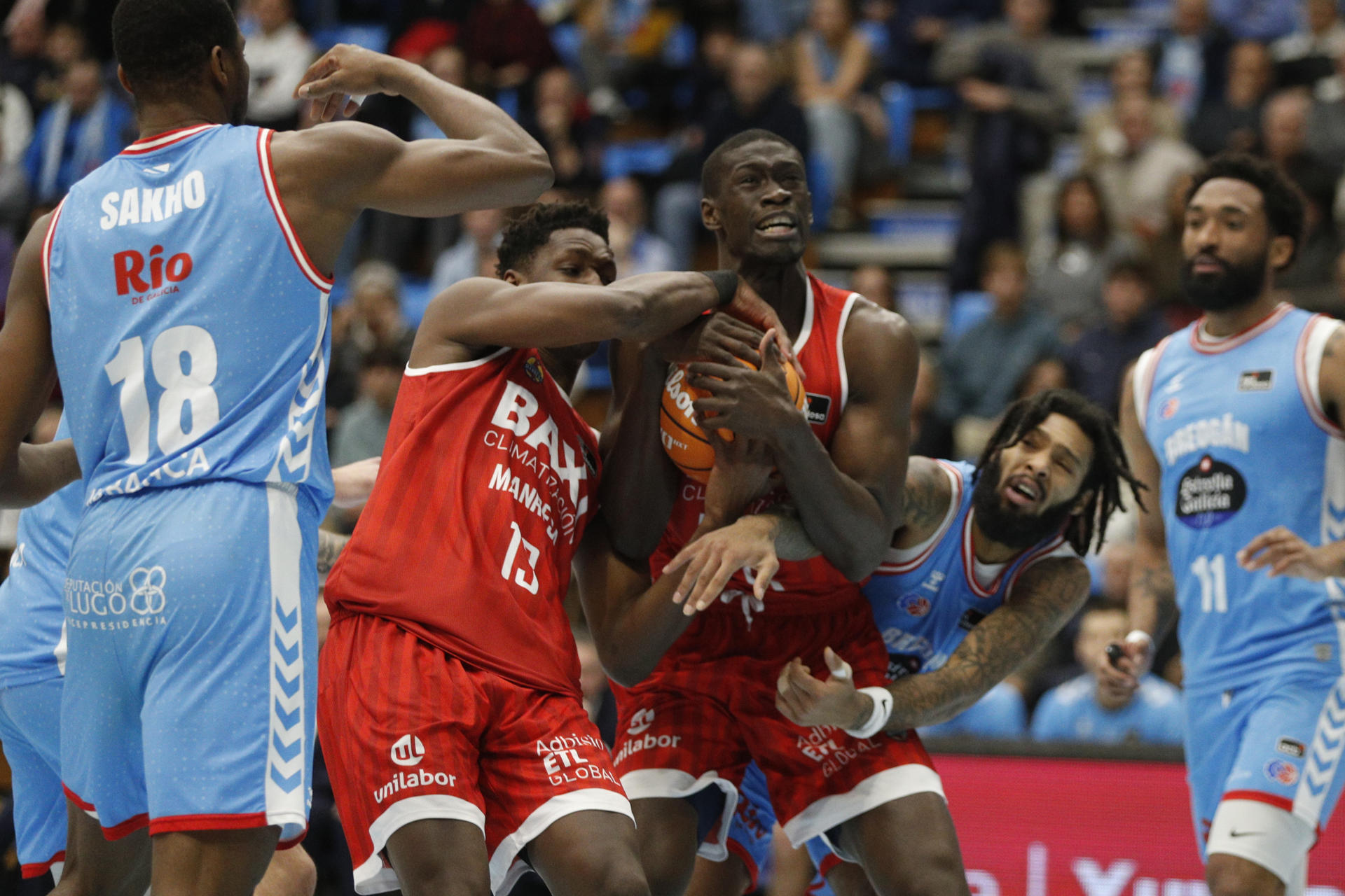 Los jugadores del Baxi Manresa Musa Sagnia (i) y Bodian Massa (c) disputan el balón con Dae Grant (d), del Río Breogán Lugo, durante el partido de la Liga Endesa ACB disputado este jueves en el Pazo Provincial dos Deportes de Lugo. EFE/Eliseo Trigo
