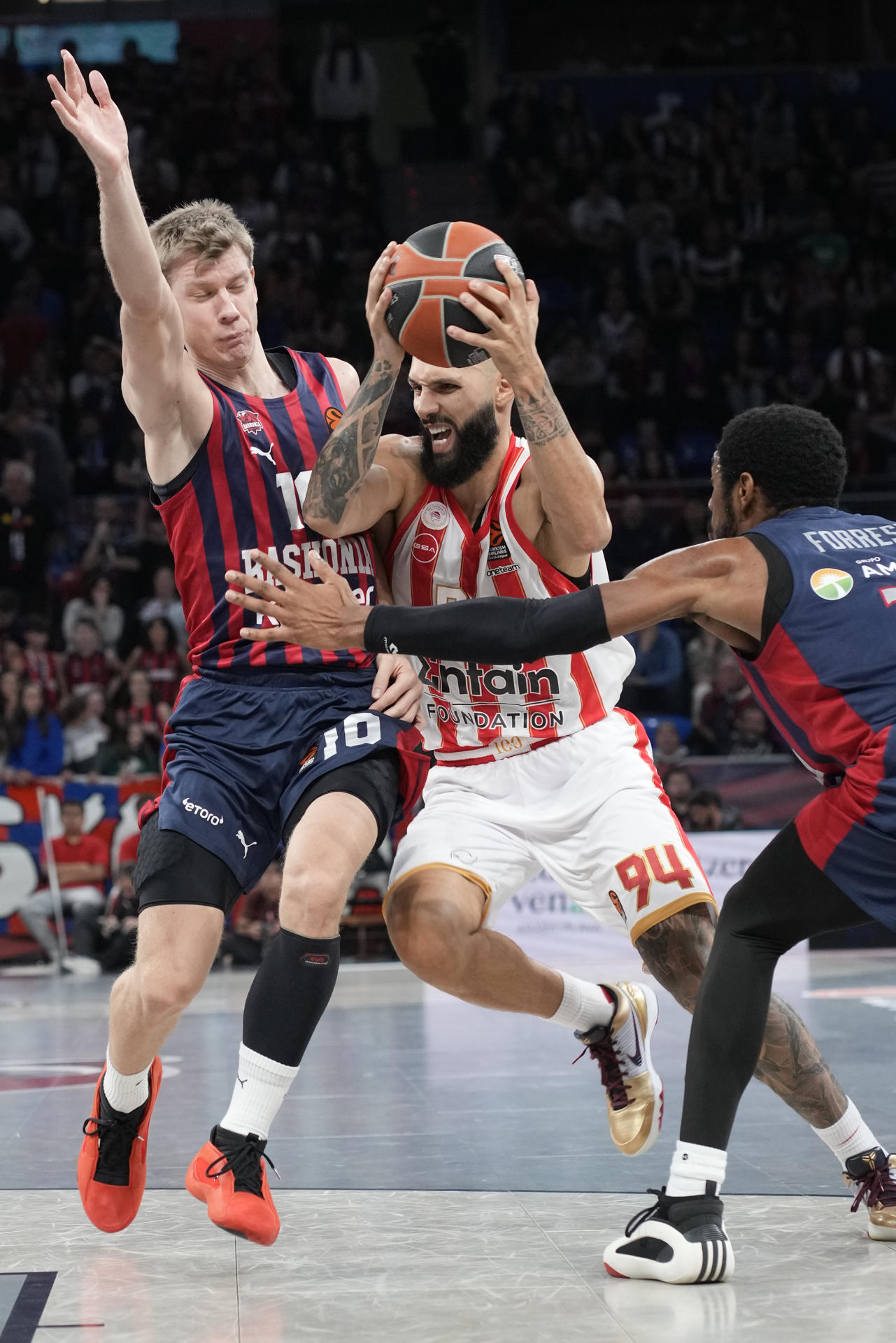 El alero francés de Olympiacos, Evan Fournier (d), intenta superar al escolta serbio del Baskonia Ognjen Jaramaz durante el encuentro correspondiente a la fase regular de la Euroliga que disputaron en el Fernando Buesa Arena de Vitoria. EFE / ADRIAN RUIZ HIERRO
