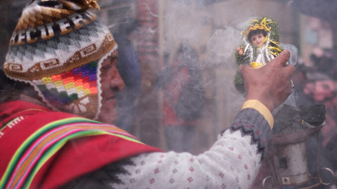 Un sacerdote aimara o 'amauta' sostiene una imagen del niño Jesús durante la misa de Reyes este lunes, en La Paz (Bolivia). EFE/ Luis Gandarillas
