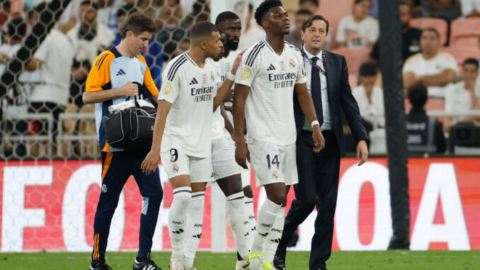 El defensa francés del Real Madrid Aurelien Tchouameni (d) abandona el terreno de juego tras lesionarse durante el partido de semifinales de la Supercopa de España de fútbol entre el Real Madrid y el RCD Mallorca, este jueves en Yeda. EFE/ Alberto Estévez
