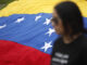 Fotografía de archivo de un mujer junto a una bandera venezolana. EFE/Rodrigo Sura