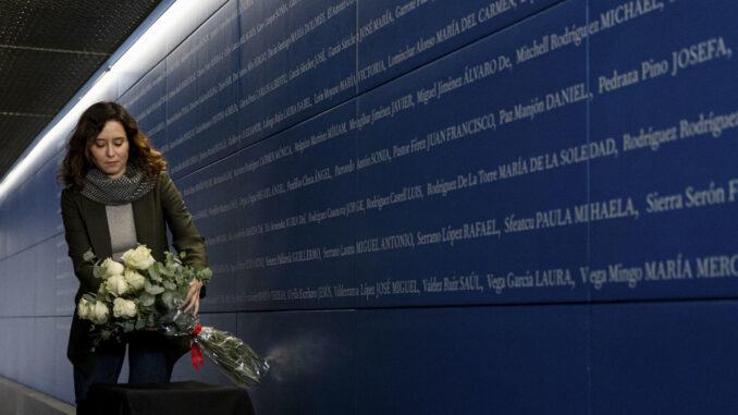 La presidenta de la Comunidad de Madrid, Isabel Díaz Ayuso, deposita un ramo de rosas junto al espacio ampliado de homenaje a las víctimas de los atentados del 11 de marzo de 2004, durante al acto de apertura de la remodelación del vestíbulo de la Estación de Atocha, este viernes. EFE/Daniel González
