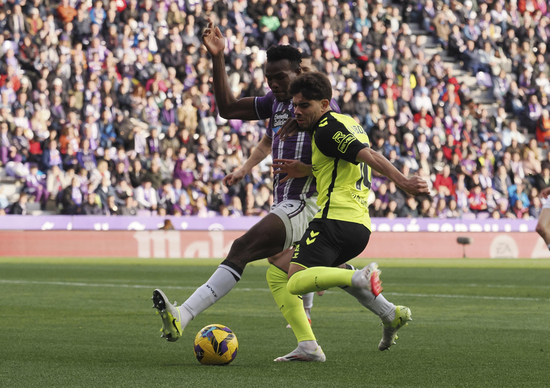 El delantero marroquí del Betis, Abde Ezzalzouli (d) pelea un balón con el defensa sierraleonés del Valladolid, Juma Bah en el partido de LaLiga que se disputó en el estadio José Zorrilla. EFE/R. GARCÍA.
