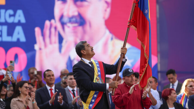 El líder chavista Nicolás Maduro ondea una bandera en un acto este viernes, en Caracas (Venezuela). EFE/ Ronald Peña R.
