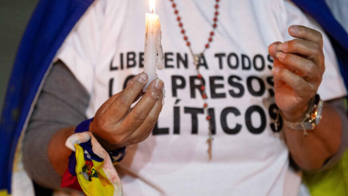 Fotografía de archivo de una mujer que sostiene una vela durante una vigilia por los "presos políticos" en la Universidad Central de Venezuela (UCV) en Caracas (Venezuela). EFE/ Ronald Peña
