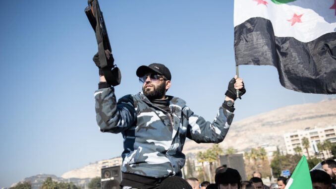 Un exprisionero de la prisión de Sednaya sostiene un arma y la bandera de la oposición siria durante una manifestación para celebrar su libertad y exigir su derecho a responsabilizar a sus carceleros, en la Plaza de los Omeyas en Damasco, Siria, 03 de enero de 2025. (Syria, Damascus) 
EFE/EPA/HASAN BELAL
