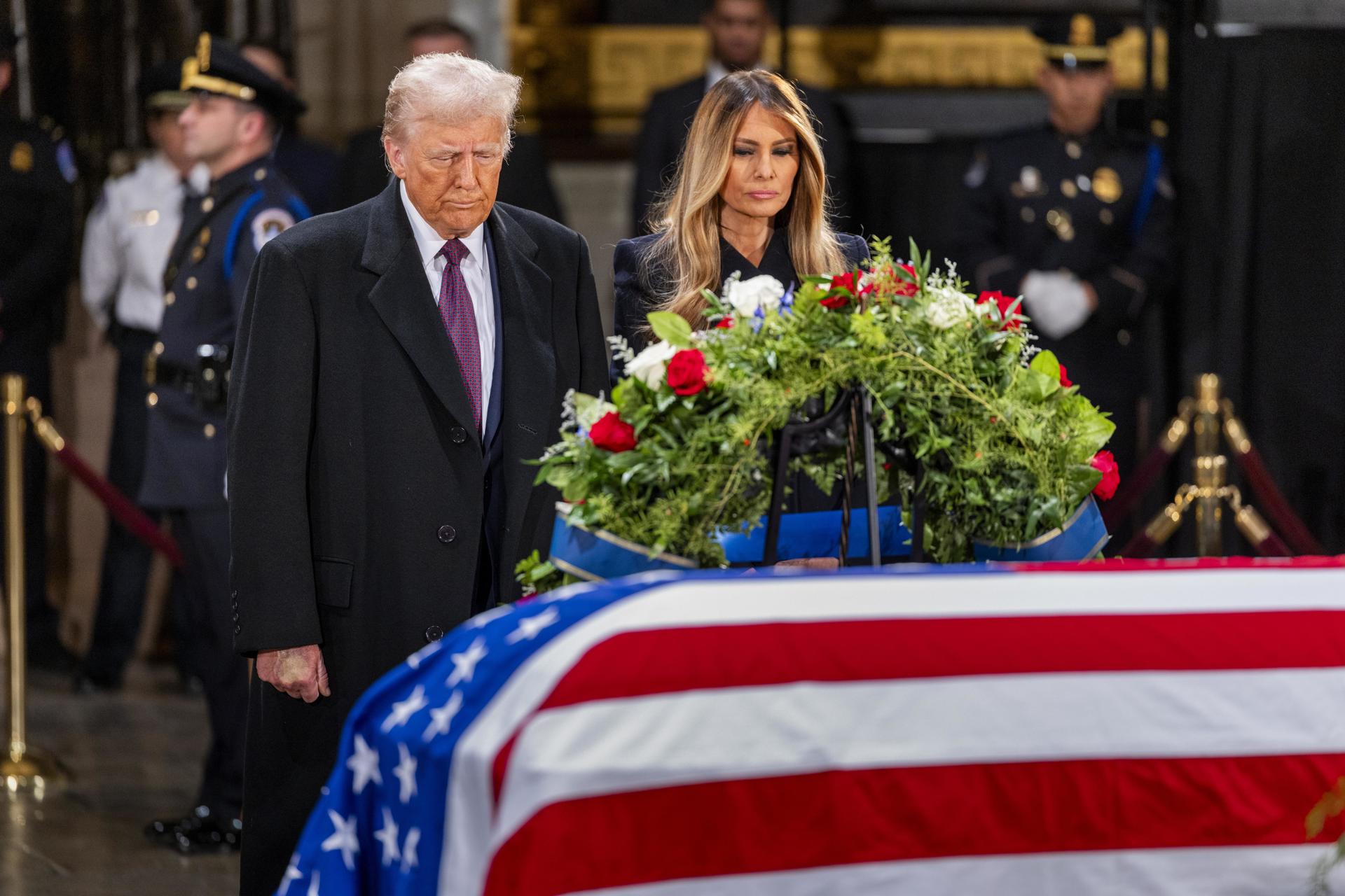 El presidente electo de Estados Unidos, Donald J. Trump, y Melania Trump se detienen ante el ataúd envuelto en la bandera del expresidente estadounidense Jimmy Carter mientras yace en la Rotonda del Capitolio de Estados Unidos en Washington, DC, EE. UU., el 8 de enero de 2025. EFE/EPA/Shawn Thew
