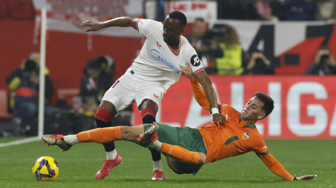 El defensa del Sevilla Adrià Pedrosa (i) celebra su gol durante el partido de la jornada 19 de LaLiga que Sevilla FC y Valencia CF disputaron en el Ramón Sánchez-Pizjuán, en Sevilla. EFE/Julio Muñoz
