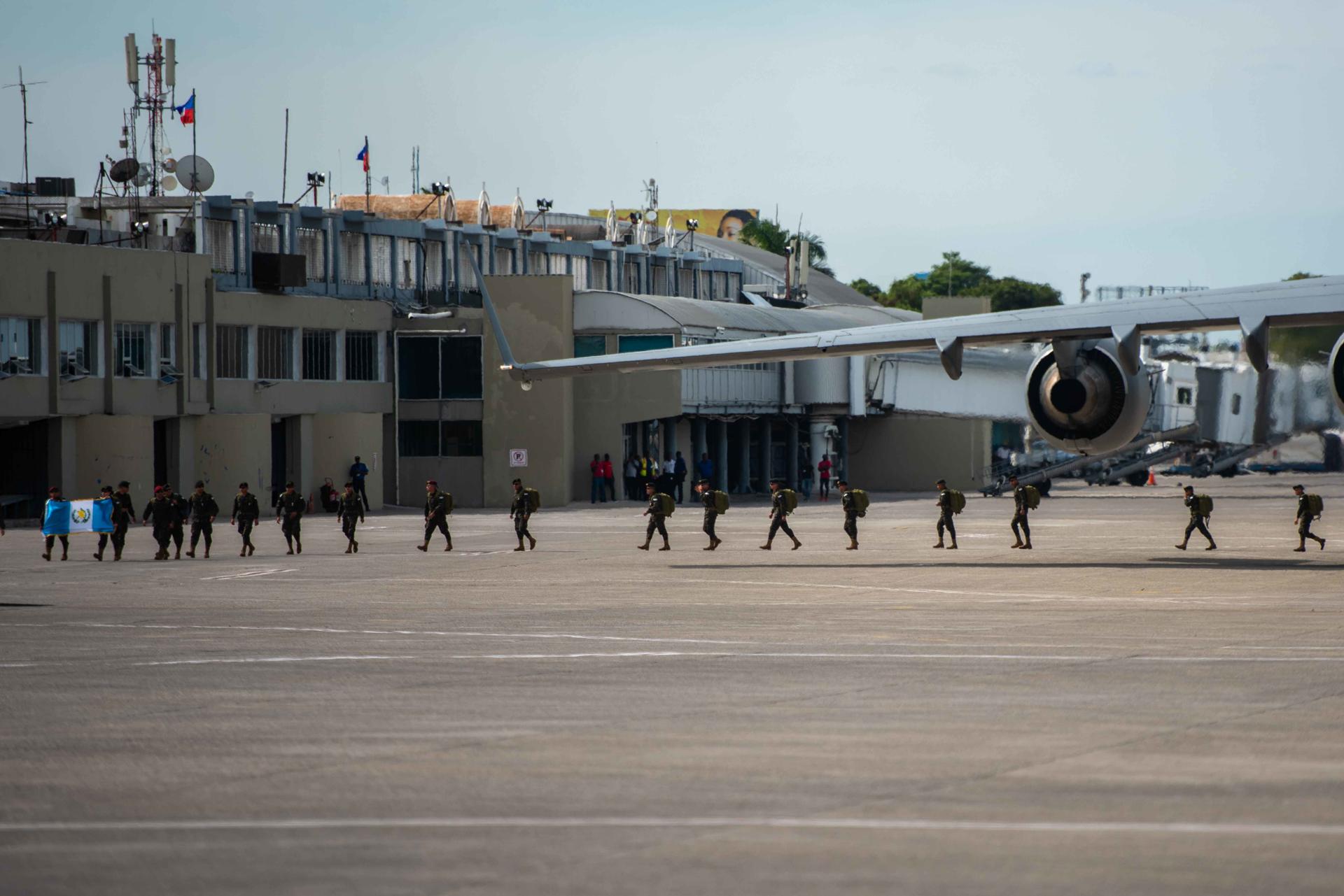 Soldados guatemaltecos caminan en fila luego de su llegada al aeropuerto Toussaint Louverture este sábado, en Puerto Príncipe (Haití). EFE/ Johnson Sabin
