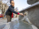 Una mujer toca el agua congelada de una fuente este jueves en Granada. EFE/Miguel Ángel Molina