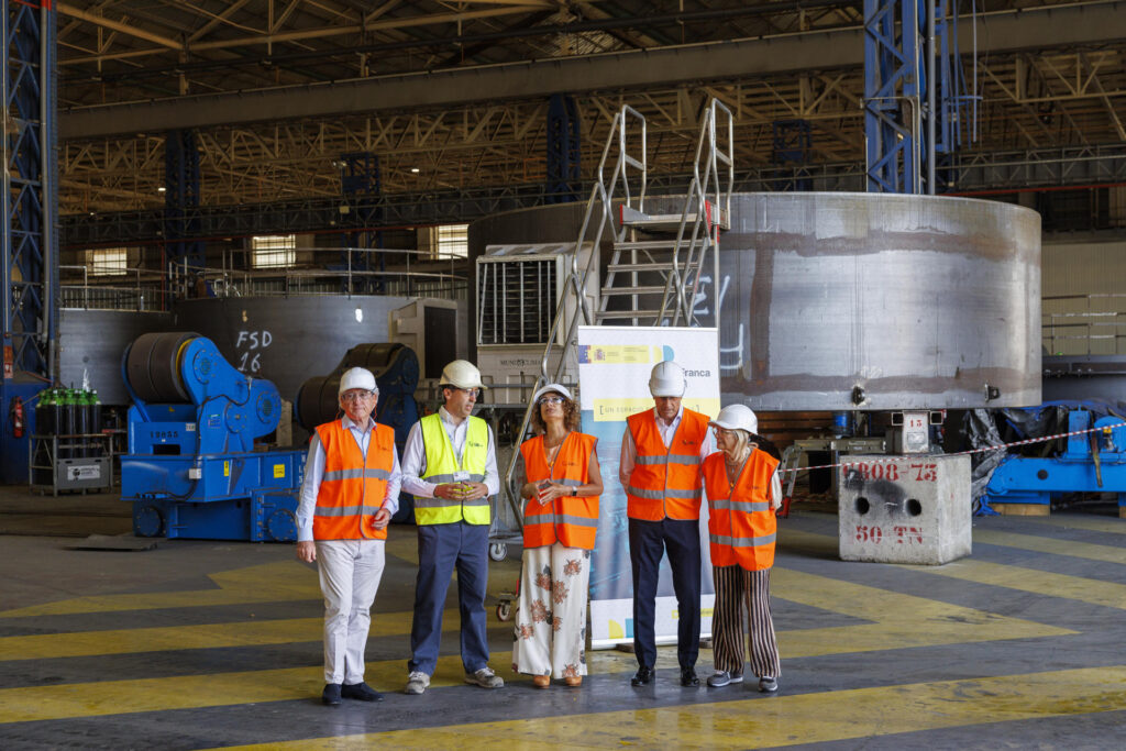 -La vicepresidenta primera del Gobierno, María Jesús Montero (c), durante la visita realizada este viernes a las instalaciones de la empresa GRI Towers, dedicada a la fabricación de componentes para turbinas eólicas, en la Zona Franca de Sevilla. EFE/ Julio Muñoz