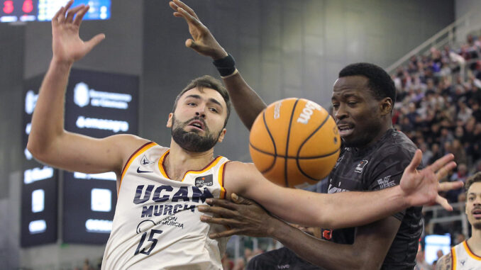 El pívot del Covirán Amida Brimah (d) pelea un balón con Emanuel Cate, del UCAM, durante el partido de la Liga Endesa de baloncesto que Covirán Granada y UCAM Murcia disputan este sábado en el Palacio de los Deportes de Granada. EFE/Pepe Torres
