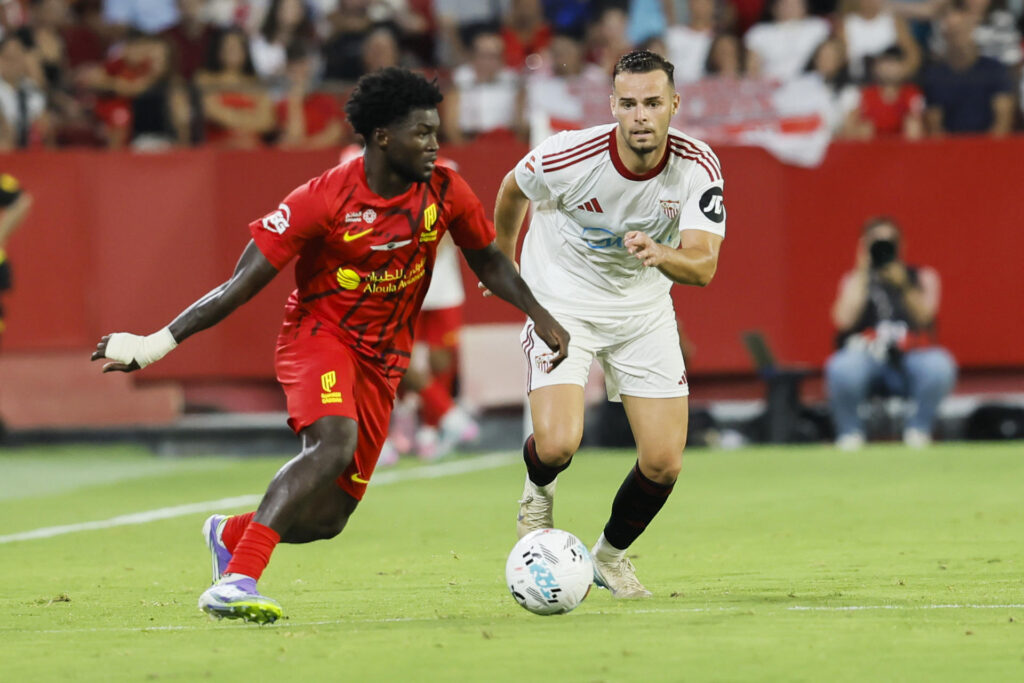 El central del Sevilla Ramón Martínez (d) persigue a Bonsu Baah, del Al-Qadsiah FC,en el estadio Sánchez-Pizjuán, en Sevilla en foto de archivo de José Manuel Vidal