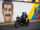 Personas transitan frente a un mural del presidente de Venezuela, Nicolás Maduro, este domingo en Caracas (Venezuela). EFE/ Ronald Peña R