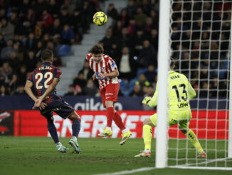 El delantero del Atlético de Madrid Julián Álvarez (c) remata a portería ante el defensa del Levante Jeremy Toljan (i) durante el encuentro correspondiente a la jornada 22 de LaLiga EA Sports entre Levante UD y Atlético de Madrid celebrado este sábado en el Estadio Ciutat de València. EFE/ Biel Aliño