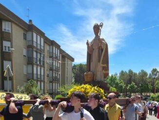 Procesión de San Julián por las calles del barrio Fuente del Oro de Cuenca con patrón acompañado por vecinos y pasete portado por jóvenes banceros