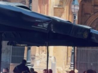 Vista de una terraza en el centro histórico de Oviedo con personas disfrutando del ambiente urbano