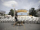 Miembros de la Policía Nacional que formarán parte del dispositivo de seguridad con motivo de la visita del Papa León XIV vigilan los asientos habilitados para la visita tras la rueda de prensa celebrada en la plaza de Lima en Madrid este viernes durante la presentación de dicho dispositivo. EFE/ Marcos Villaoslada