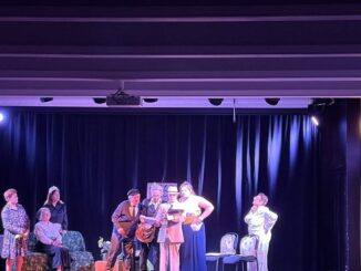 Escena de la representación teatral Cuatro corazones con freno y marcha atrás con participantes del taller en escena