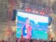 Multitud de personas celebrando en la Plaza María Pita de A Coruña durante la noche con pantallas LED mostrando contenido deportivo del Mundial de fútbol