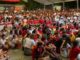 Concentración de vecinos en la Plaza de los Arcos de Sevilla la Nueva durante el minuto de silencio en memoria de Aysha, con la bandera de España visible de fondo