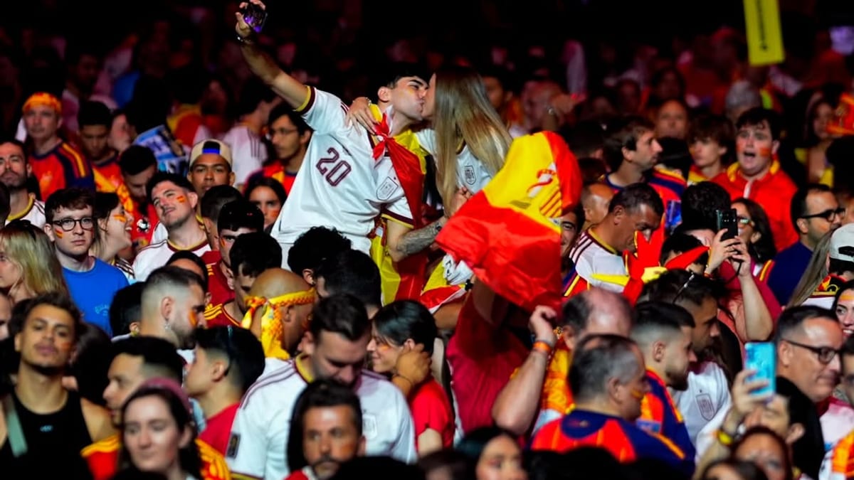Multitud de aficionados en evento deportivo vistiendo equipos de fútbol en rojo, amarillo y blanco durante Copa Mundial FIFA