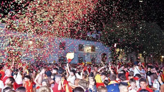 Concentración de vecinos en la Plaza de la Constitución de Villaviciosa de Odón celebrando la segunda estrella mundialista de España con pantalla gigante