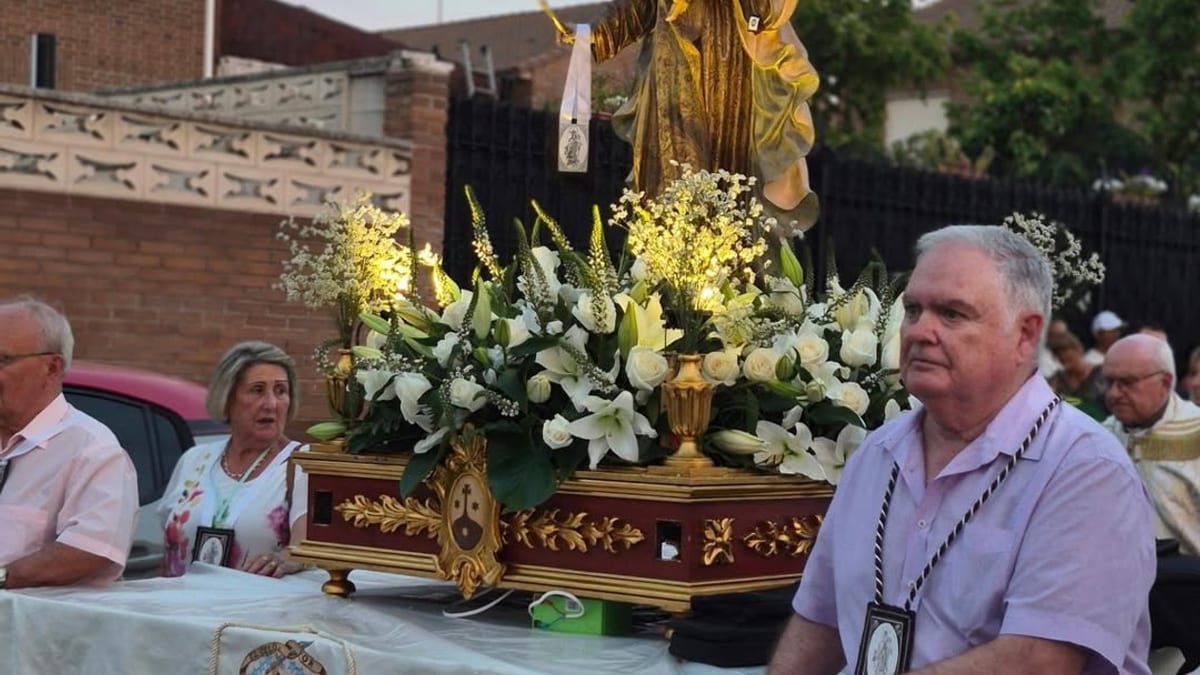 Procesión de la Virgen del Carmen en La Poveda con imagen dorada decorada con flores blancas y vecinos participando