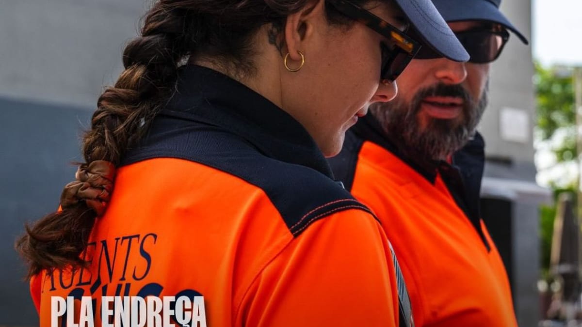 Agente cívico de Barcelona identificado con uniforme naranja y emblema del Ayuntamiento