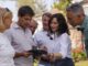 Grupo de personas en jardín de vivienda de Soto de Viñuelas durante visita de la presidenta de la Comunidad de Madrid