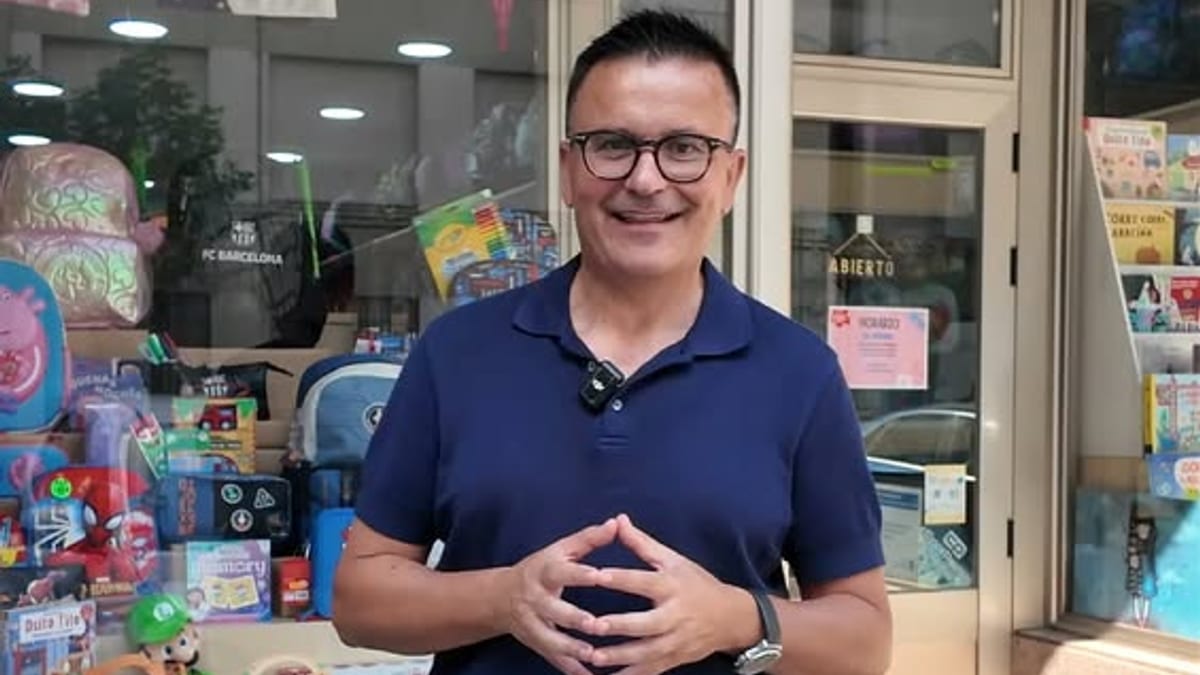 Persona frente a una tienda con escaparate en una calle comercial de Galicia