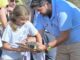 Evento de devolución de tortuga al mar en Lorca, con educador mostrando ejemplar a público en la Cala de Calnegre