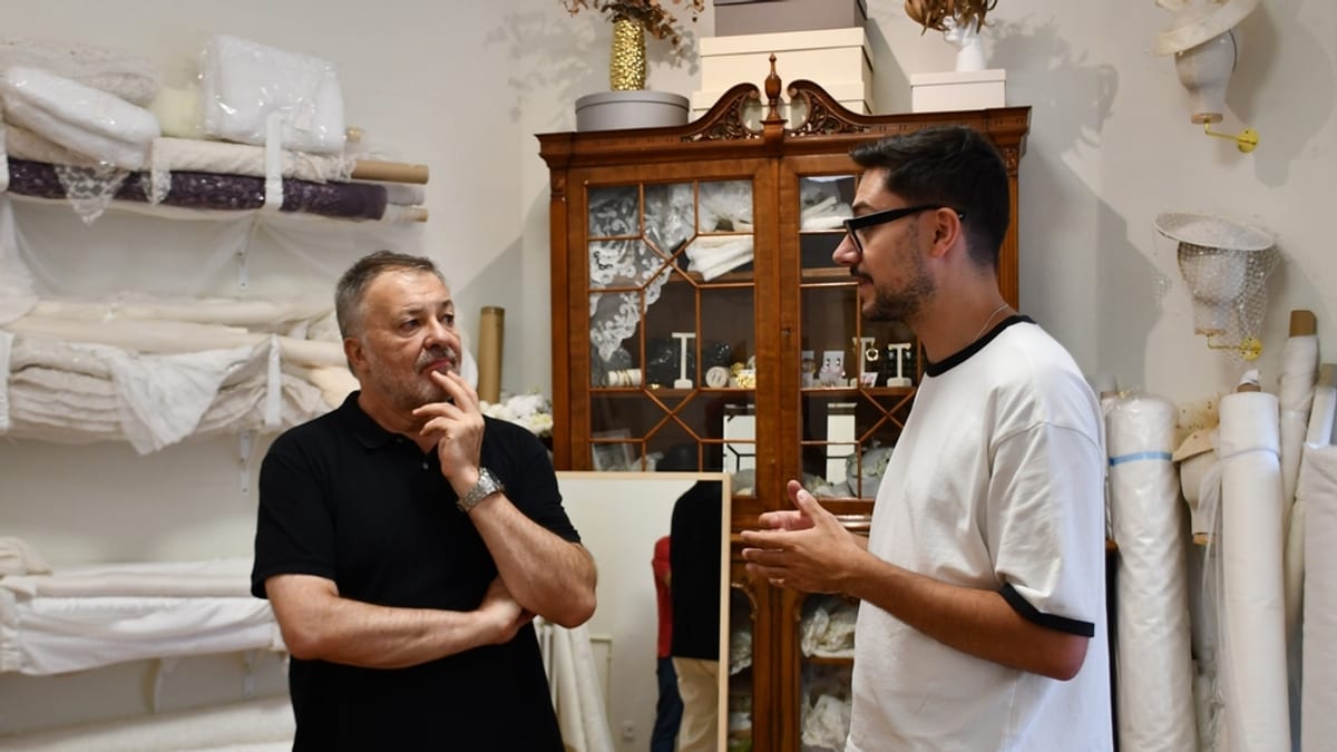Señorito Ortega conversando en su atelier con estanterías de textiles y productos artesanales