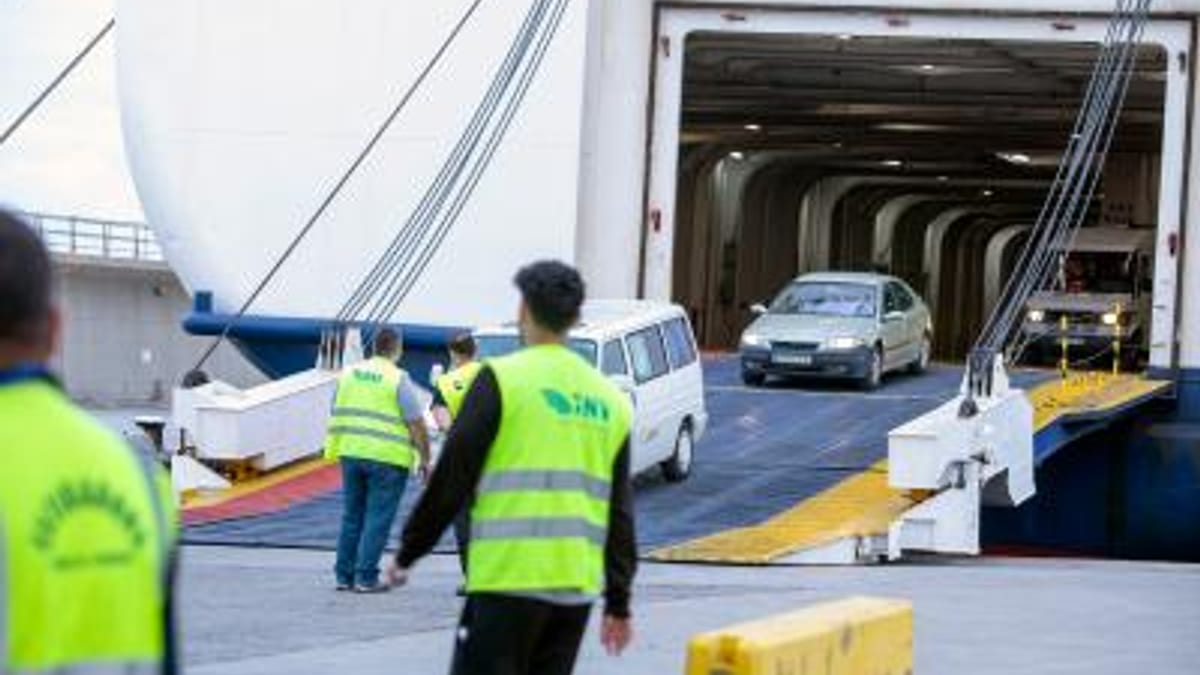 Carga y descarga de vehículos en el puerto de Ibiza con operarios en equipo de seguridad