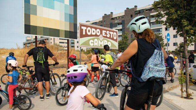 Participantes en ruta en bicicleta observando arte urbano en Rivas Vaciamadrid