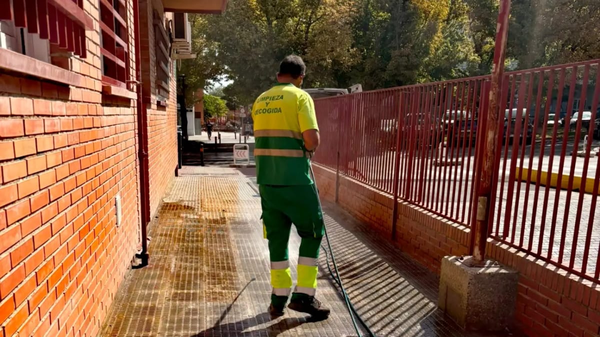 Operario realizando labores de baldeo en las calles de San Fernando de Henares durante el programa especial de agosto