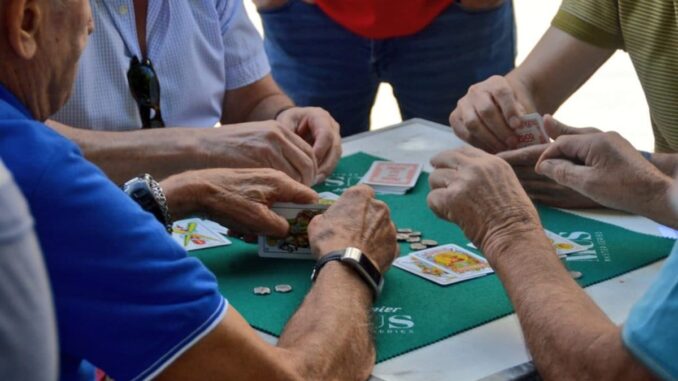 Abierto el plazo para inscribirse en el Gran Torneo de Mus de Ferias Grupo de personas jugando al mus alrededor de una mesa verde durante un torneo