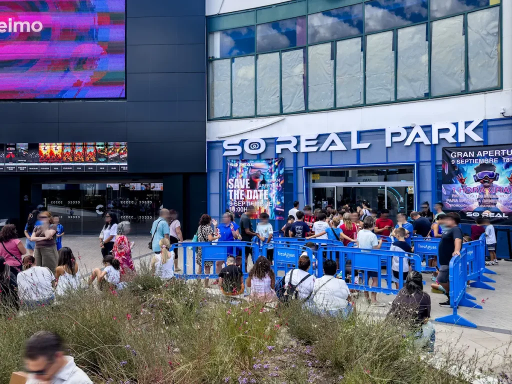 Multitud de personas esperando la apertura de So Real Park tras vallas azules en el centro comercial TresAguas.