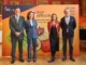Cuatro personas posando frente al cartel naranja de Fruit Attraction 2026 de IFEMA Madrid con dibujos de frutas y verduras.