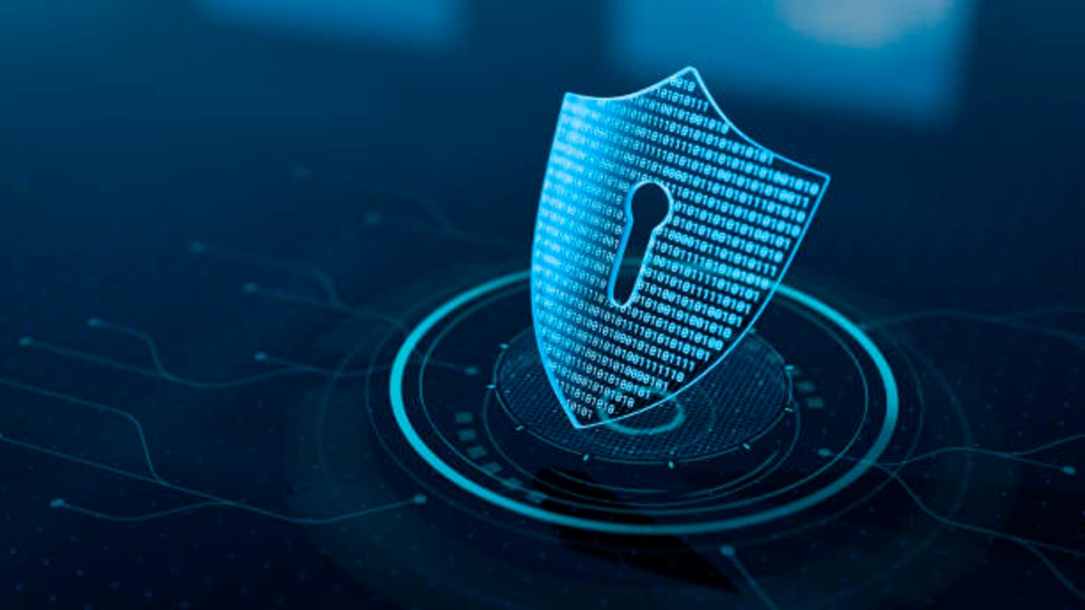 Escudo digital con símbolo de candado sobre fondo tecnológico azul que representa la protección y ciberseguridad