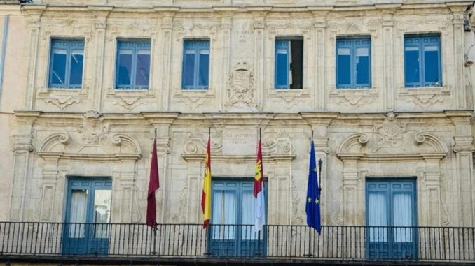 Vista de un edificio histórico de Cuenca con arquitectura clásica y banderas