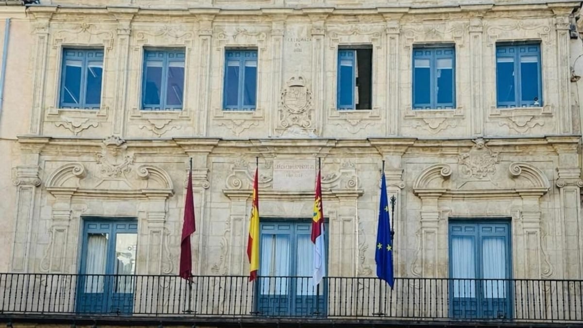 Vista de un edificio histórico de Cuenca con arquitectura clásica y banderas