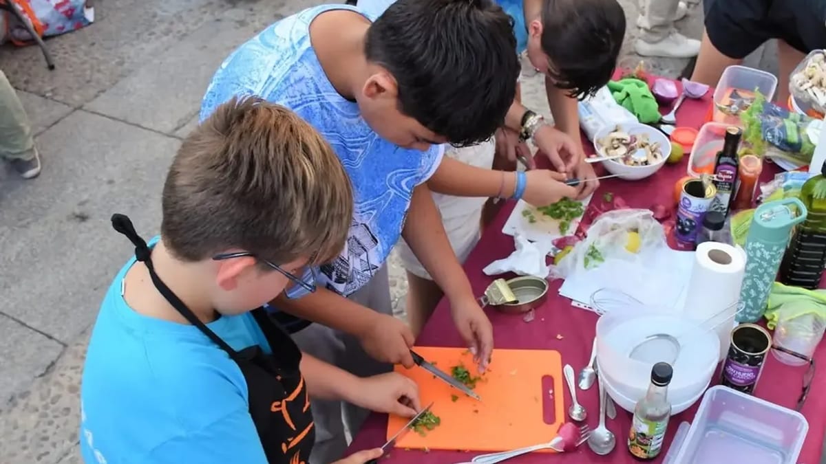Participantes cocinando juntos en la Plaza de la Constitución de Villaviciosa de Odón durante la actividad de las Fiestas 2026