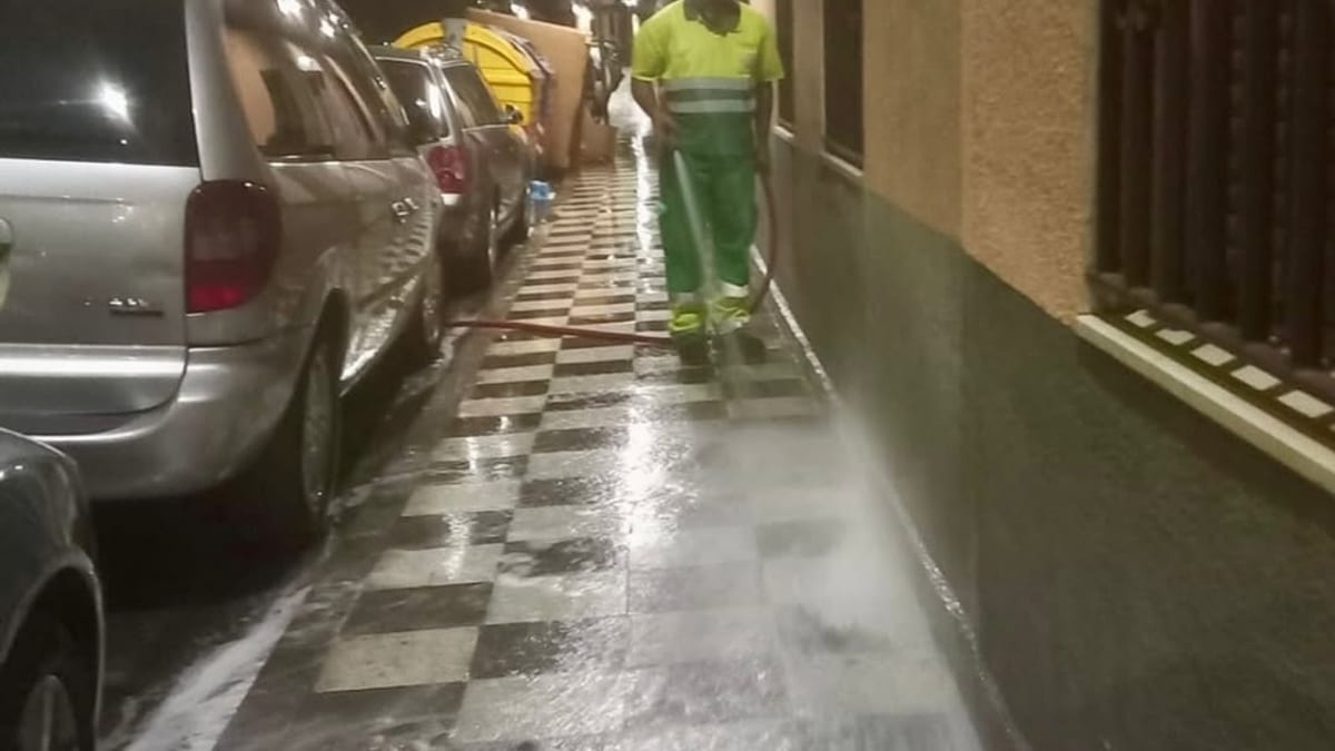 Equipo municipal realizando limpieza nocturna con agua a presión en acera de Cuenca