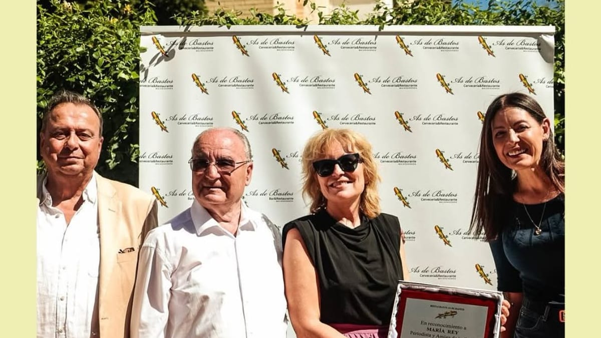 Representantes del As de Bastos sostienen placa conmemorativa del 27º aniversario durante las Fiestas de Majadahonda 2026