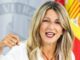 Mujer en acto oficial con bandera de España de fondo durante presentación de normativa de Formación y Empleo