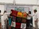 Grupo de personas sosteniendo textiles tradicionales decorativos del bordado carbajalino en estructura de malla para el Manto de los Territorios Vivos